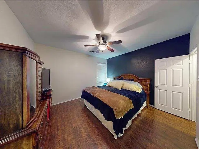 a bedroom with bed and wooden floor