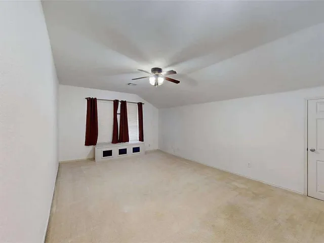 an empty room with windows and ceiling fan view
