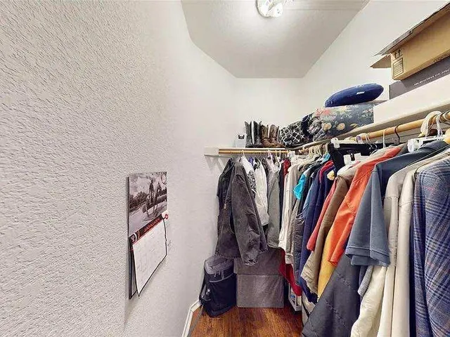 a view of walk in closet with clothes and shoes