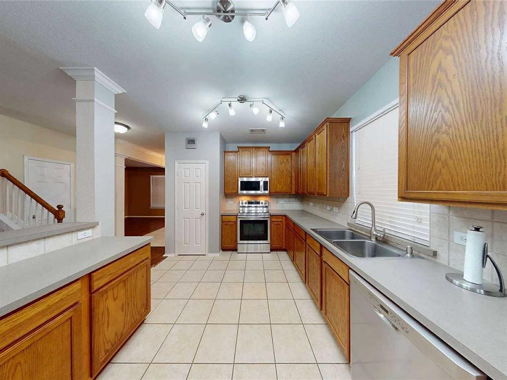 109 Greenfield Trail Forney, TX 75126 - Photo 2 of 26 a large kitchen with stainless steel appliances kitchen island granite countertop a sink counter space cabinets and a large window