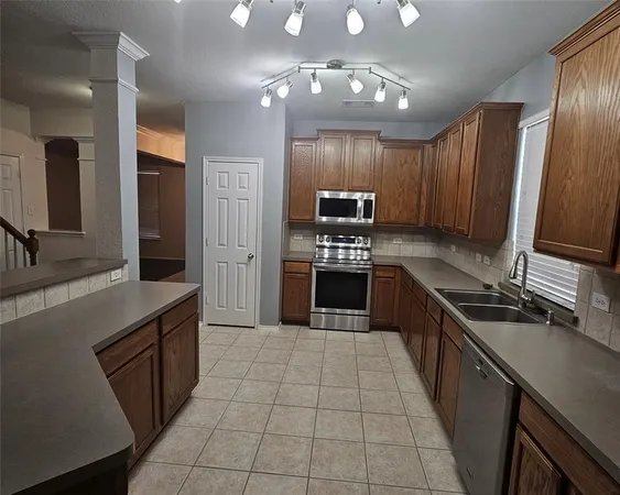 a kitchen with stainless steel appliances granite countertop a refrigerator stove and sink