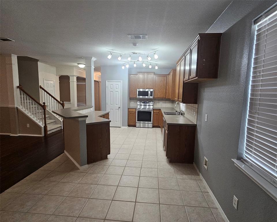 109 Greenfield Trail Forney, TX 75126 - Photo 6 of 26 a large kitchen with stainless steel appliances kitchen island granite countertop a refrigerator and a stove top oven
