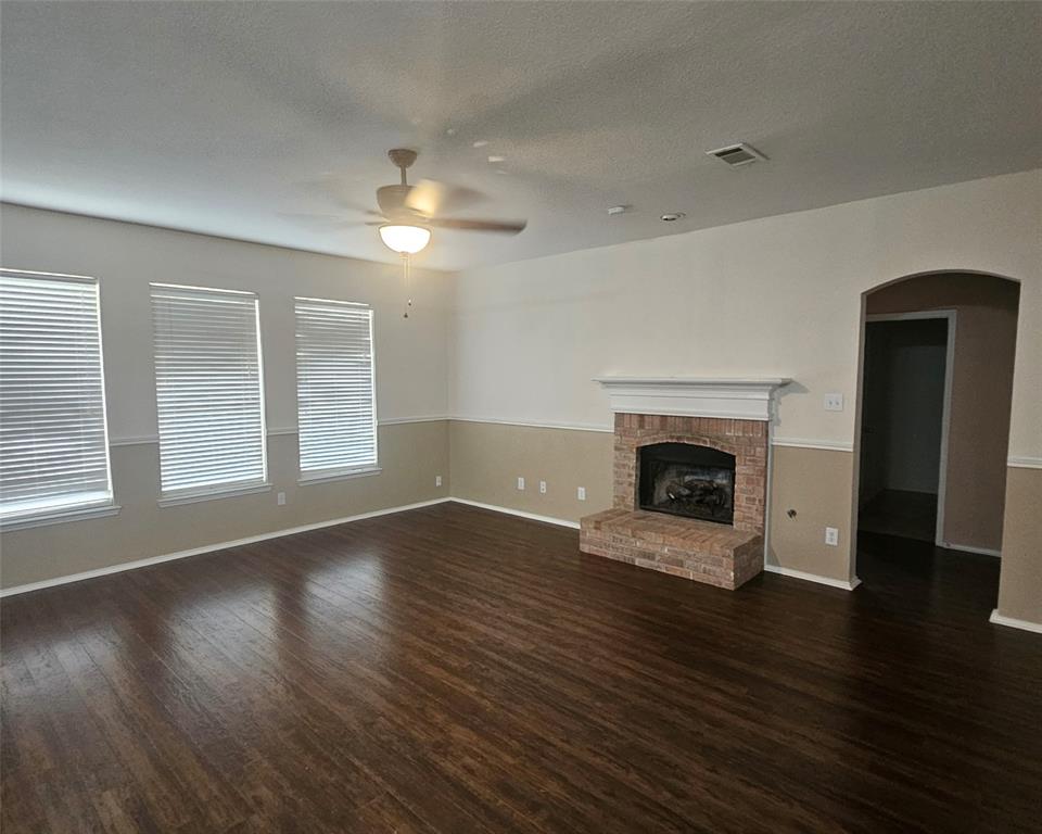 109 Greenfield Trail Forney, TX 75126 - Photo 10 of 26 an empty room with wooden floor fireplace and windows