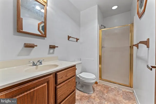 a bathroom with a granite countertop sink toilet and shower