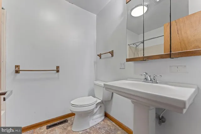 a bathroom with a sink a toilet and mirror
