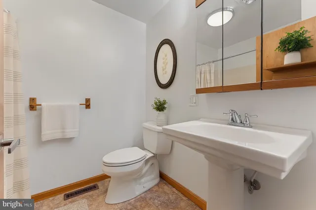 a bathroom with a sink a toilet and a mirror