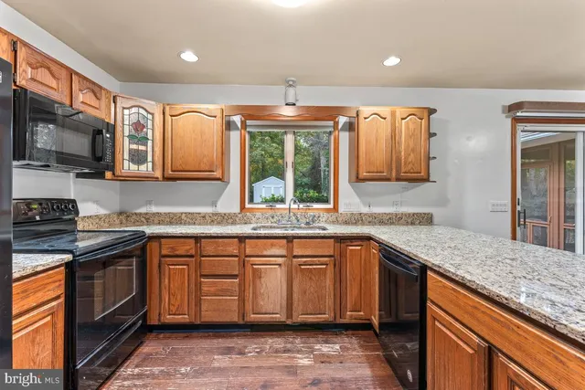 a kitchen with stainless steel appliances granite countertop a sink stove and cabinets