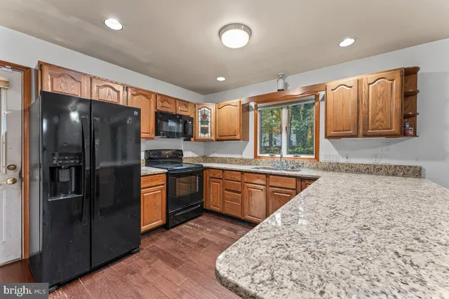 a kitchen with stainless steel appliances granite countertop a refrigerator and a stove top oven