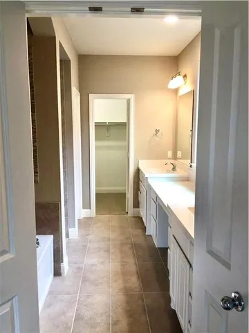 a bathroom with a granite countertop sink a mirror and a bathtub