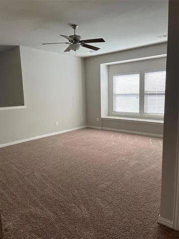 a view of a livingroom with a ceiling fan and window