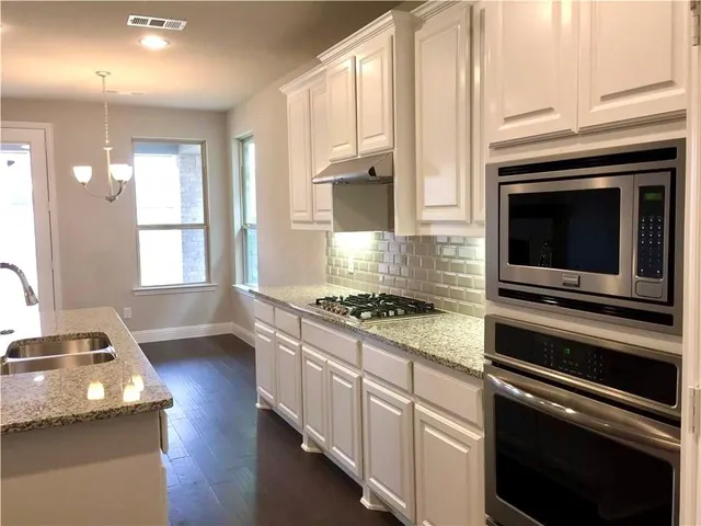 a kitchen with granite countertop a stove and a sink
