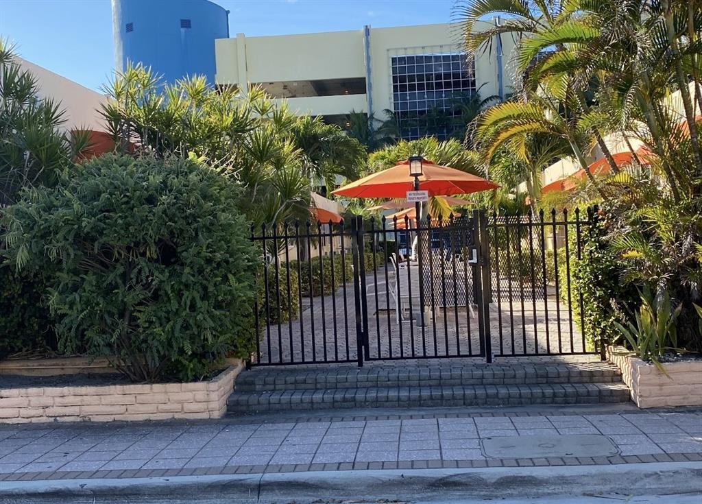 330 Arthur Street, Unit 115 Hollywood, FL 33019 - Photo 12 of 17 a view of a patio with a table and chairs under an umbrella
