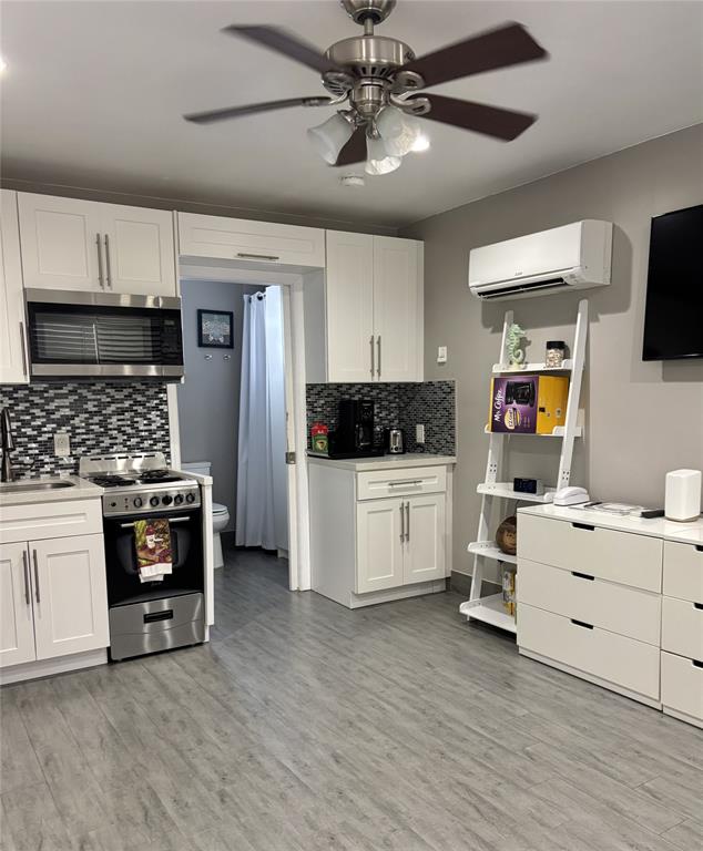 330 Arthur Street, Unit 115 Hollywood, FL 33019 - Photo 2 of 17 a kitchen with stainless steel appliances a stove cabinets and wooden floor