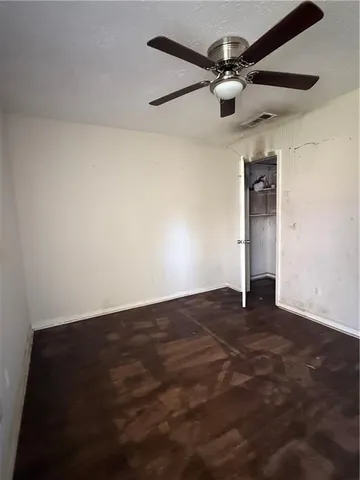 an empty room with a ceiling fan and a window
