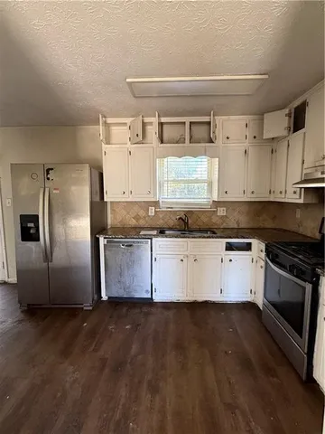 a kitchen with granite countertop a refrigerator and a stove