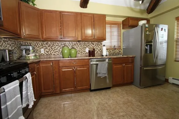 a kitchen with stainless steel appliances granite countertop a refrigerator stove and sink