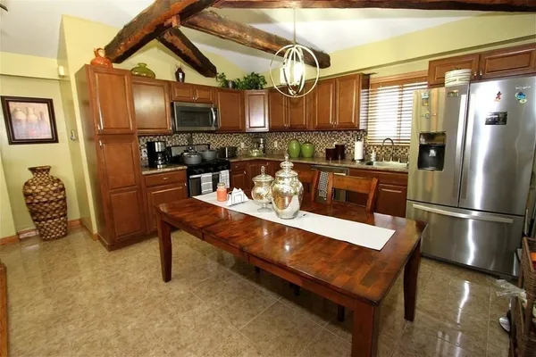a kitchen with stainless steel appliances granite countertop a sink a stove and a refrigerator