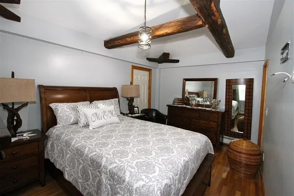 a bedroom with a bed and a flat tv screen on dresser