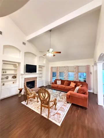 a living room with furniture a fireplace and a flat screen tv