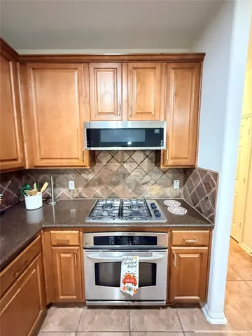 a kitchen with granite countertop stainless steel appliances a stove a sink and a microwave