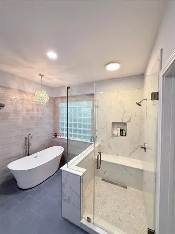 a spacious bathroom with a tub sink and mirror
