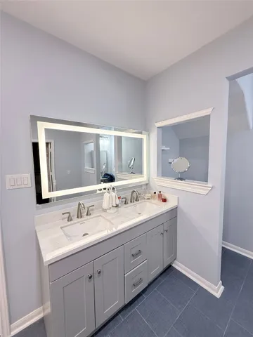 a bathroom with a double vanity sink and mirror