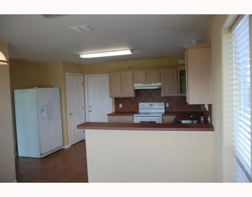 a kitchen with kitchen island granite countertop a sink cabinets and stainless steel appliances