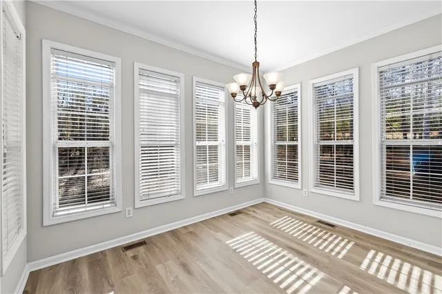 a view of an empty room with window and wooden floor
