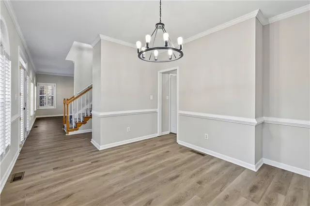 a view of staircase with wooden floor and white walls