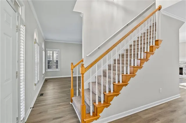 a view of an empty room with wooden floor and windows