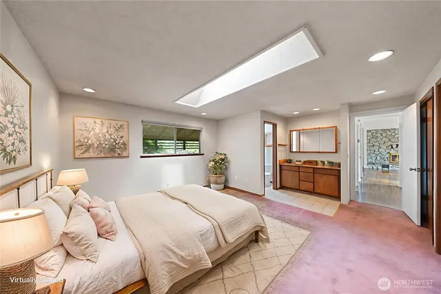 a spacious bedroom with a bed and a view of kitchen