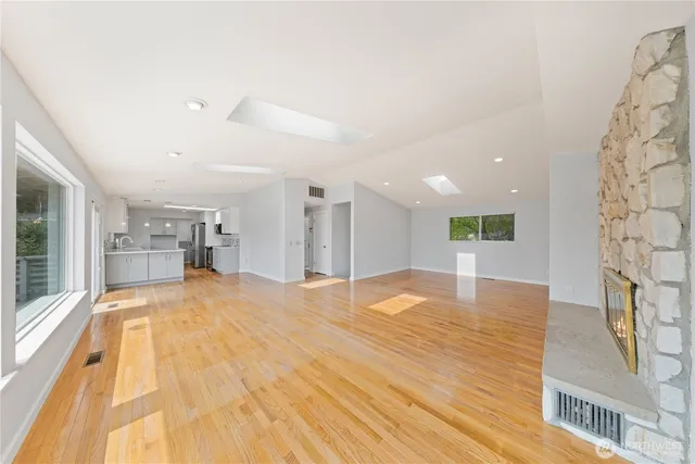a view of a kitchen with kitchen island a sink wooden floor and a fireplace