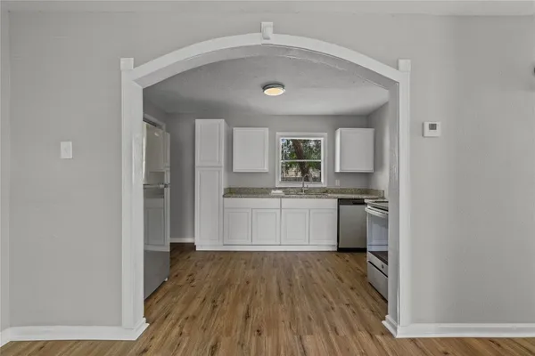 a kitchen with a refrigerator and white cabinets