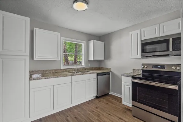 a kitchen with stainless steel appliances granite countertop a stove microwave and sink