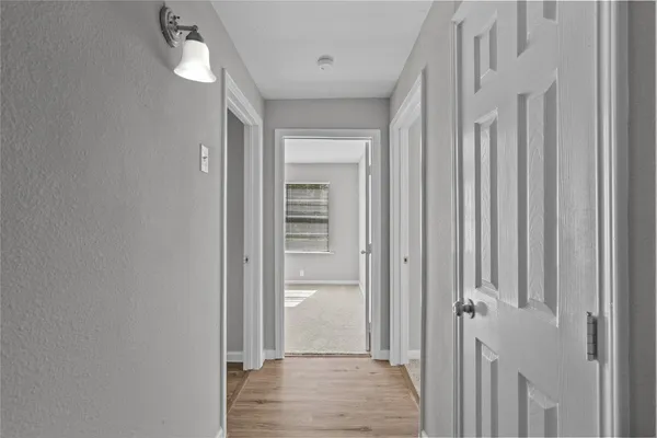 a view of a hallway with wooden floor