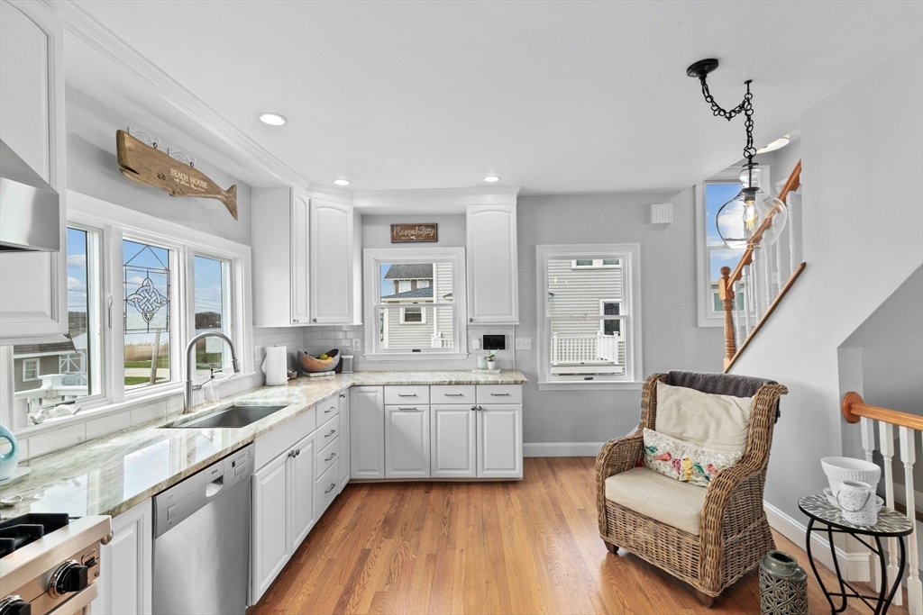 79 Surfside Road Scituate, MA 02066 - Photo 9 of 42 a large white kitchen with a window wooden floor and stainless steel appliances