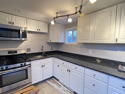 a kitchen with granite countertop cabinets stainless steel appliances and a sink