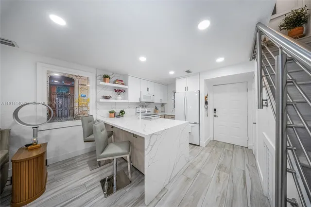 a kitchen with a sink a refrigerator and wooden floor