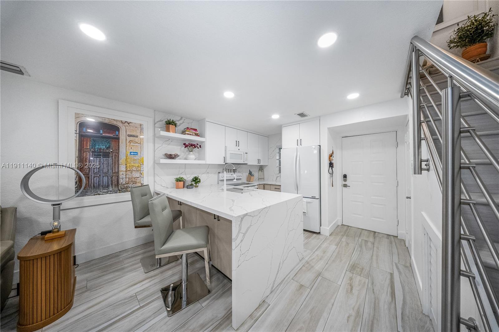 3130 Bird Avenue, Unit 12 Miami, FL 33133 - Photo 1 of 23 a kitchen with a sink a refrigerator and wooden floor