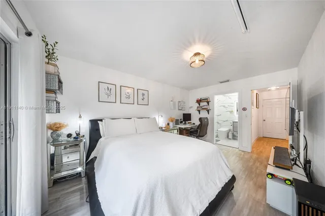 a spacious bedroom with a bed and a chandelier
