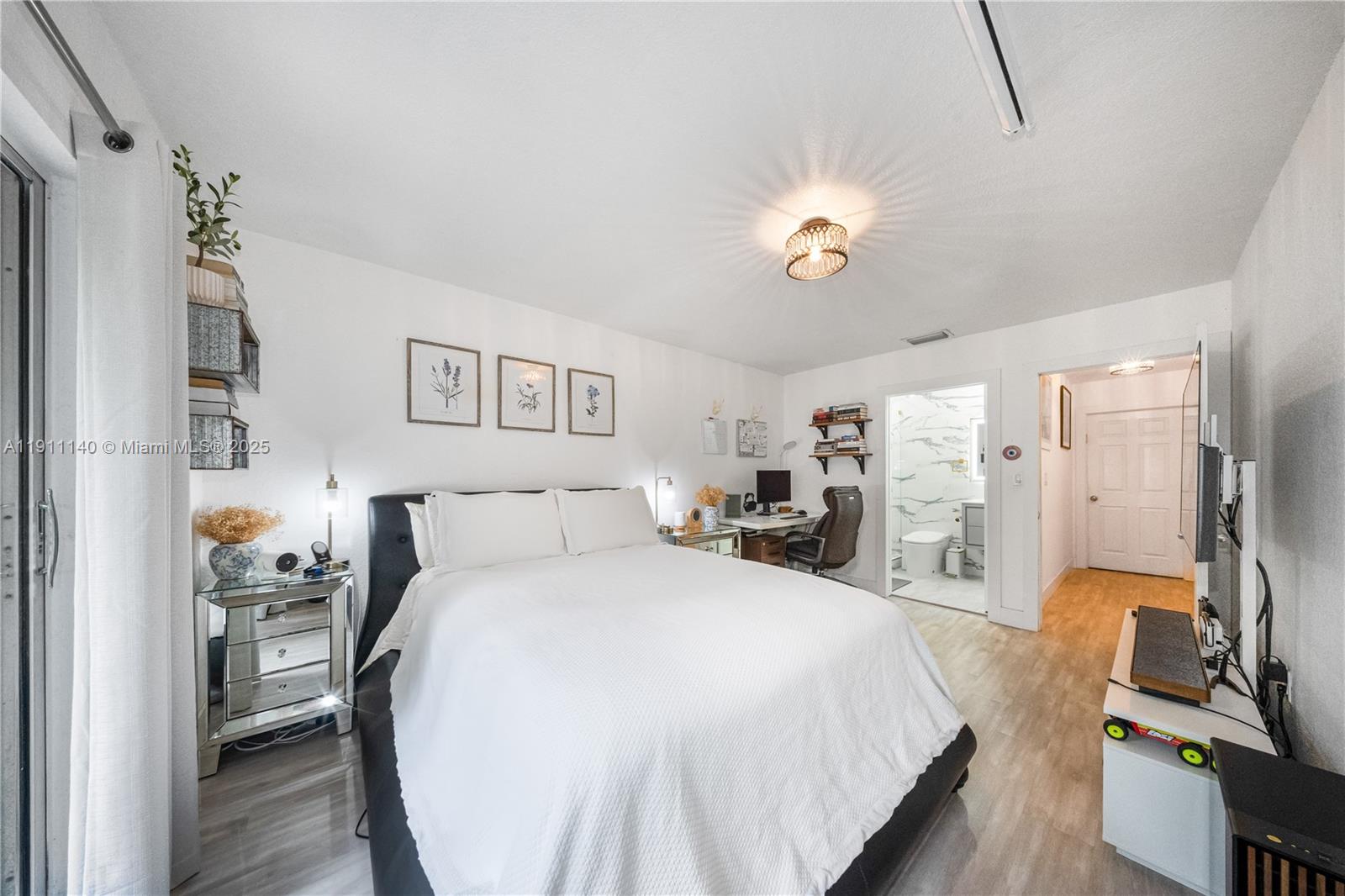 3130 Bird Avenue, Unit 12 Miami, FL 33133 - Photo 16 of 23 a spacious bedroom with a bed and a chandelier