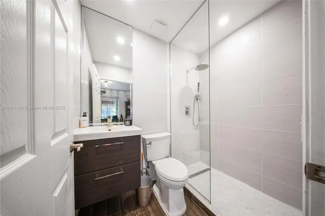 a bathroom with a granite countertop sink toilet and shower