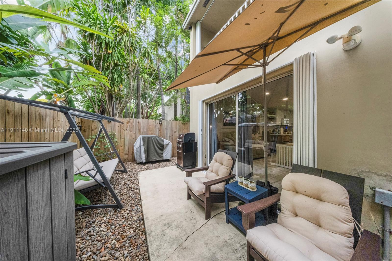 3130 Bird Avenue, Unit 12 Miami, FL 33133 - Photo 23 of 23 a backyard of a house with barbeque oven table and chairs