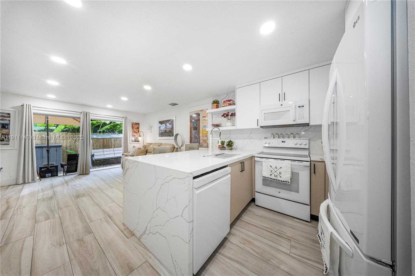 3130 Bird Avenue, Unit 12 Miami, FL 33133 - Photo 7 of 23 a kitchen with stainless steel appliances sink refrigerator and microwave
