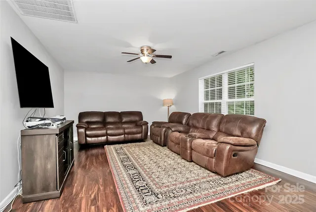 a living room with furniture a flat screen tv and a window