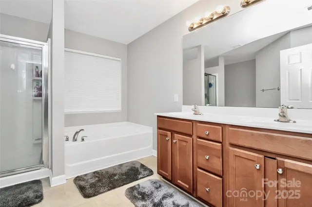 a spacious bathroom with a tub sink and mirror