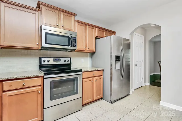 a kitchen with stainless steel appliances granite countertop a refrigerator stove and sink