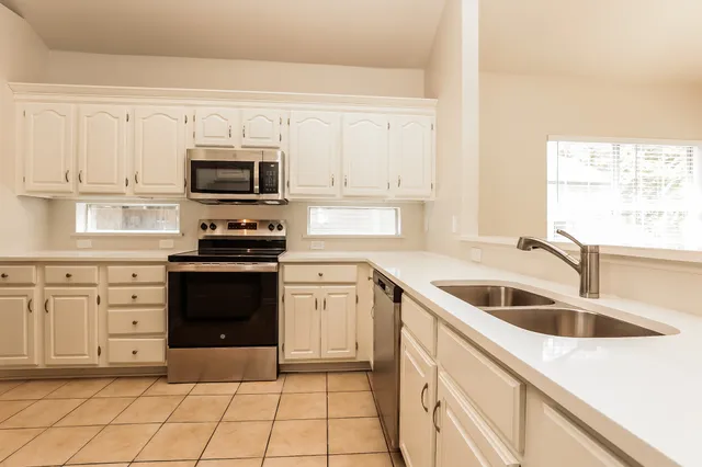 a kitchen with granite countertop a sink and steel appliances