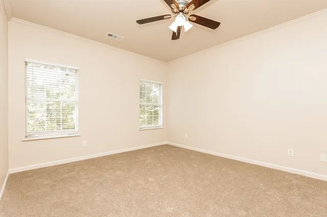 an empty room with a window and a fan
