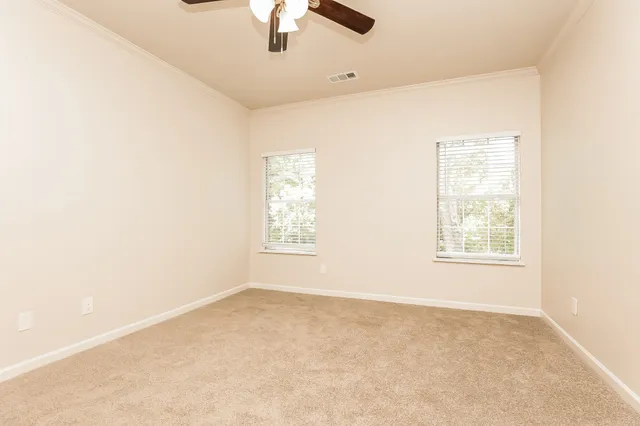 an empty room with a window and a ceiling fan